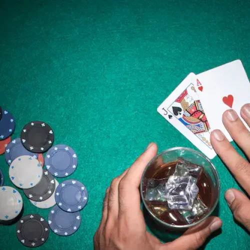 poker-player-showing-jack-ace-card-with-casino-chips-green-poker-table_23-2147881216
